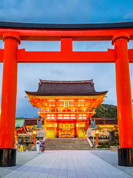 Fushimi Inari Shrine entrance with large red torii gate in Kyoto, Japan.
