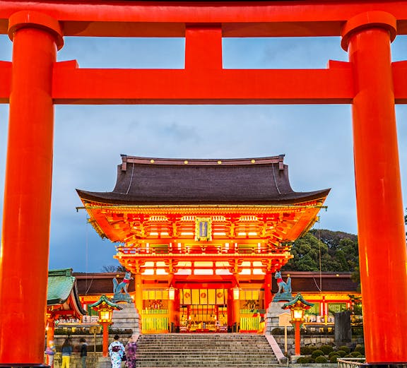 Fushimi Inari Shrine entrance with large red torii gate in Kyoto, Japan.