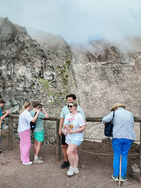 Visitors taking photos at the Mount Vesuvius crater viewpoint.