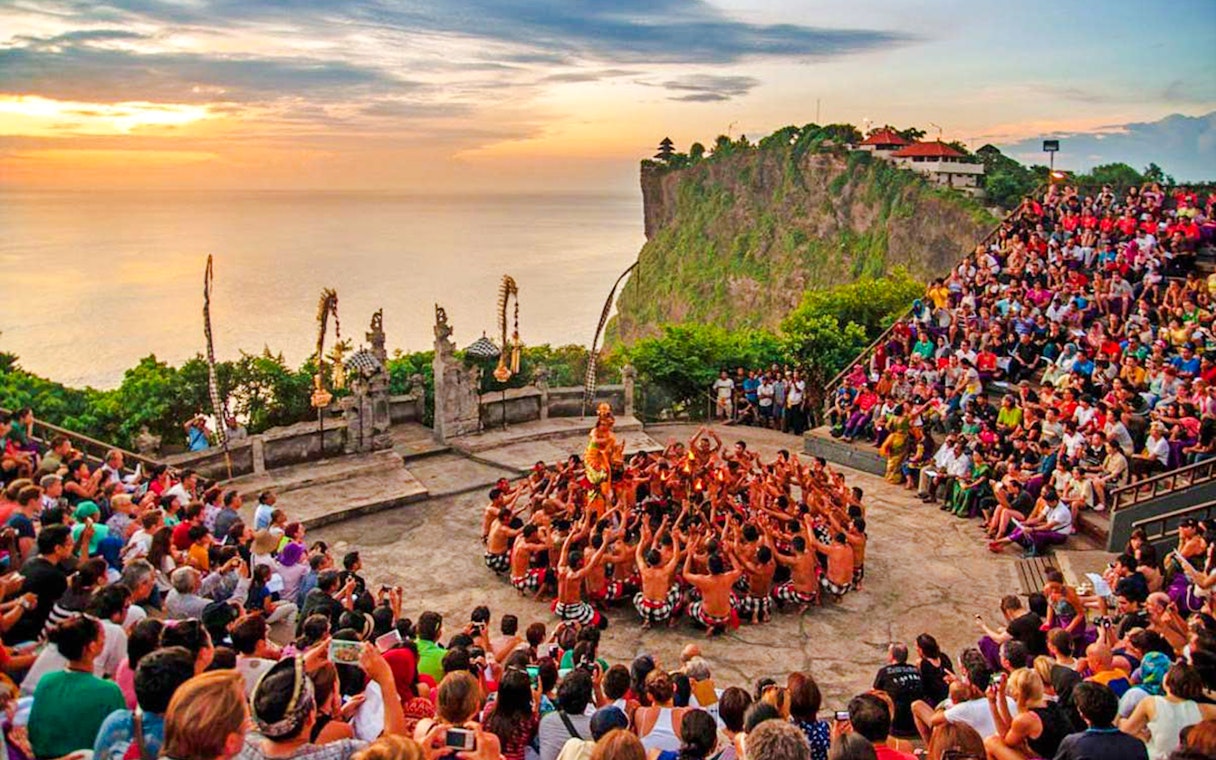 Uluwatu Kecak and Fire Dance performance at sunset with ocean view in Bali.