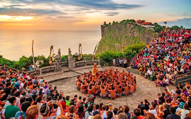 Uluwatu Kecak and Fire Dance performance at sunset with ocean view in Bali.