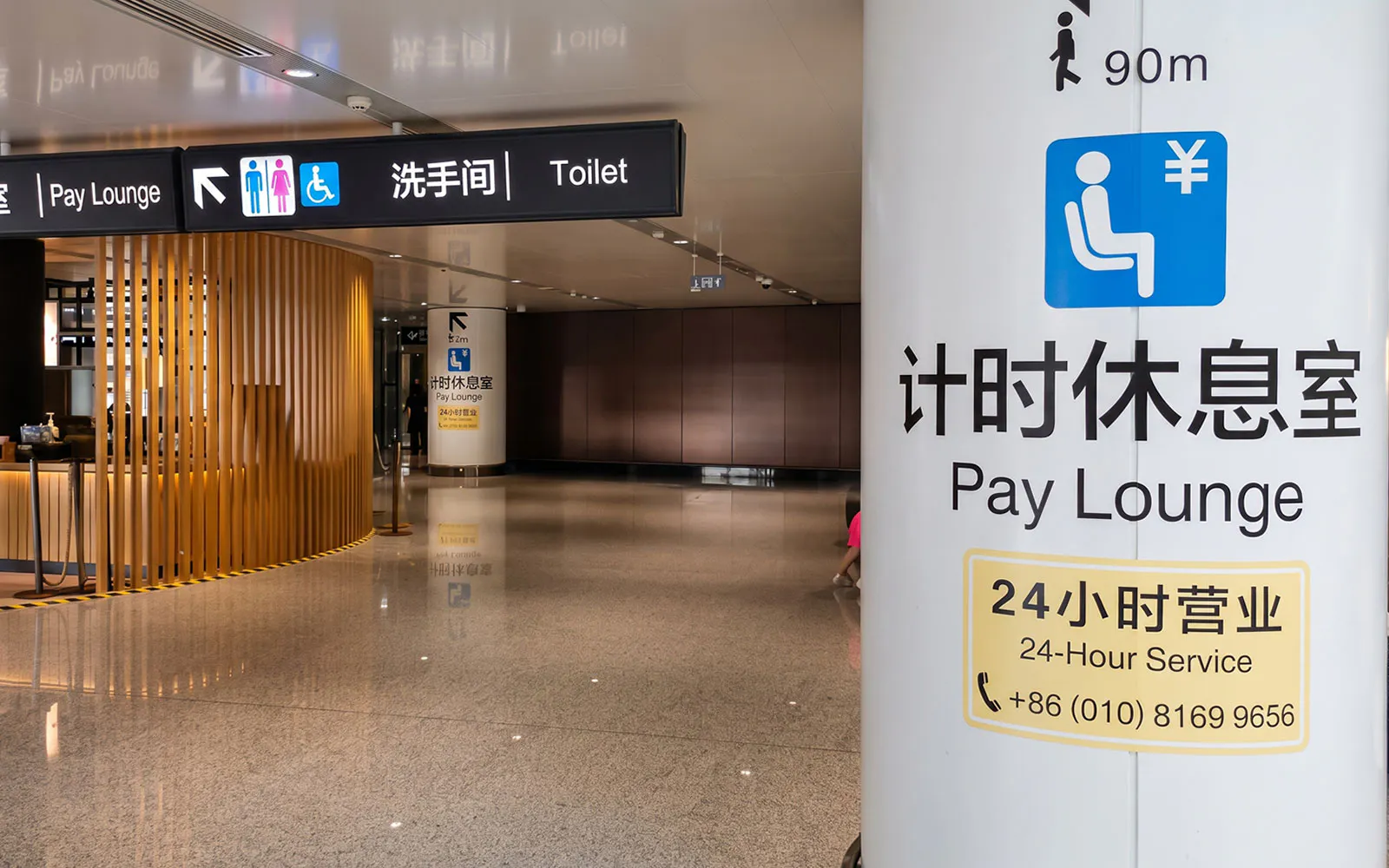 Pay lounge signage at Beijing Daxing International Airport with 24-hour service information.