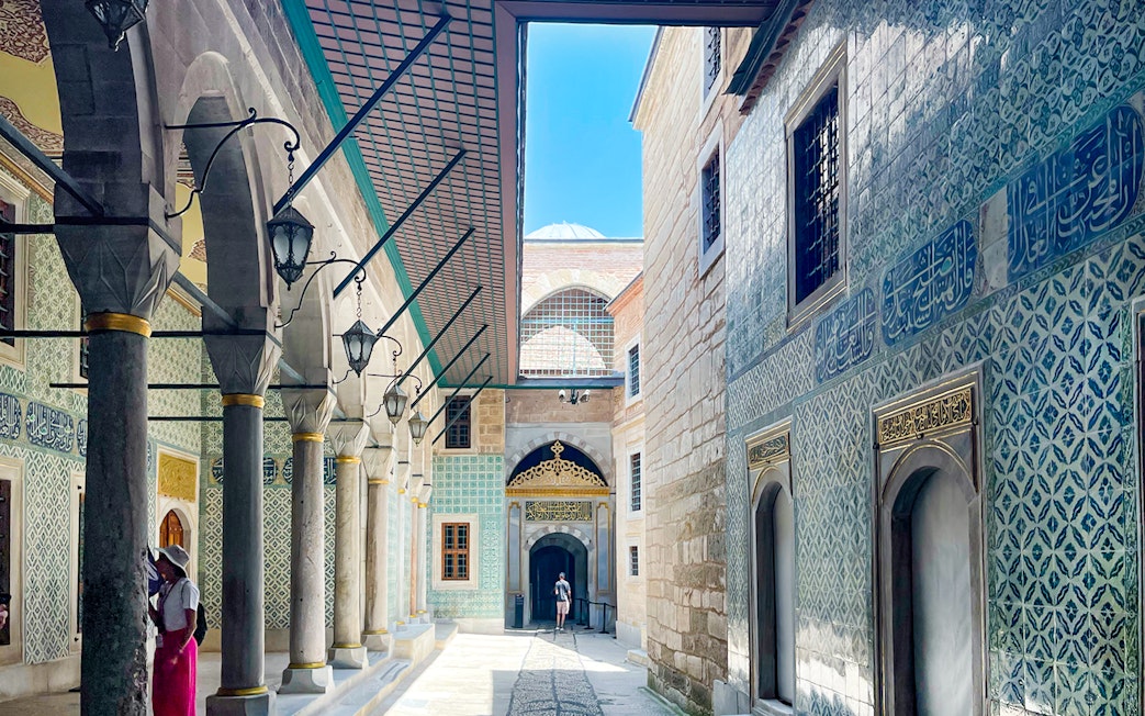Topkapi Palace courtyard with ornate tile walls and arched walkway, Istanbul.