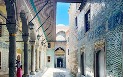 Topkapi Palace courtyard with ornate tile walls and arched walkway, Istanbul.