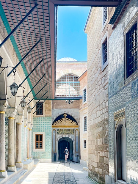 Topkapi Palace courtyard with ornate tile walls and arched walkway, Istanbul.