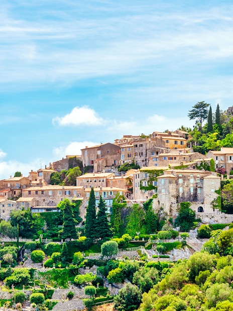 Medieval village of Eze on a hillside, featuring stone buildings and lush greenery, French Riviera.