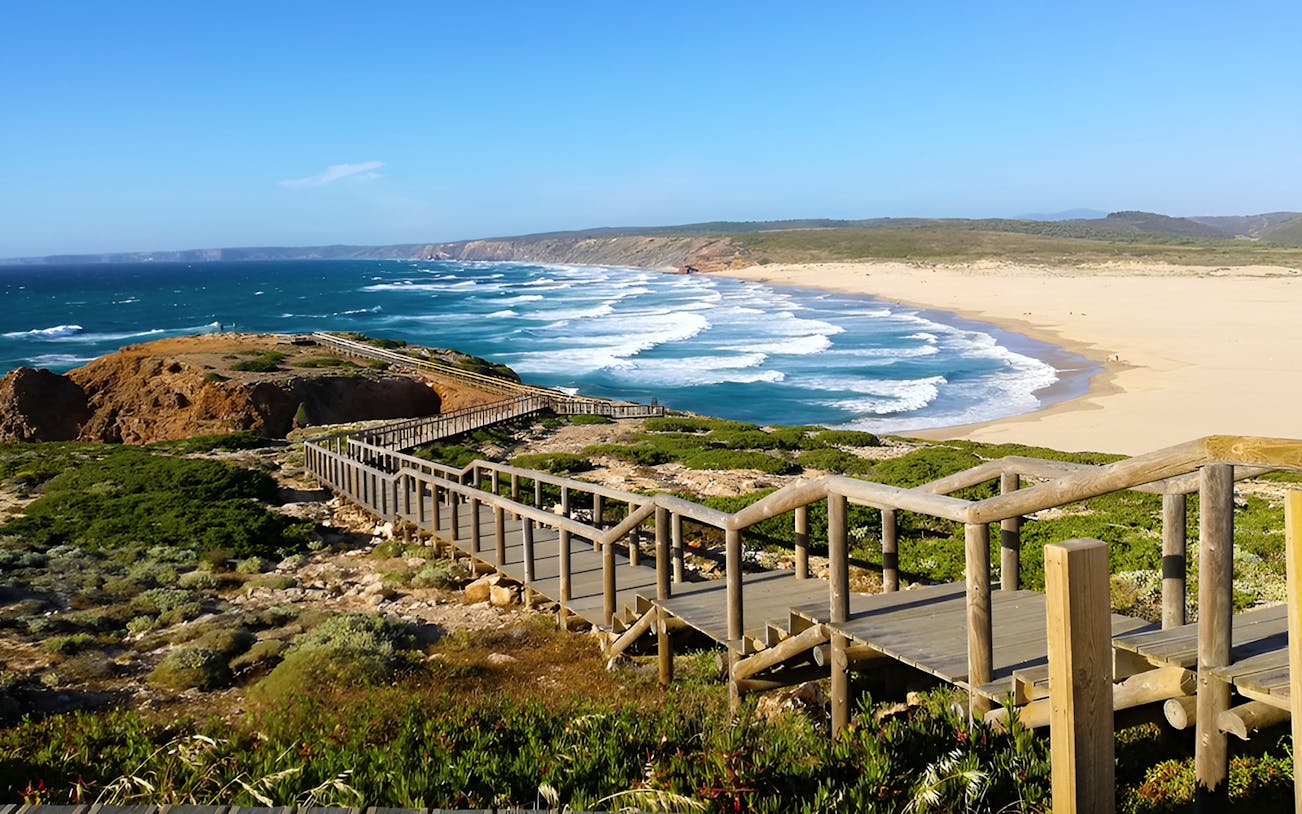 Wooden walkway overlooking beach and ocean at Vicentina Coast, Southwest Alentejo Natural Park.