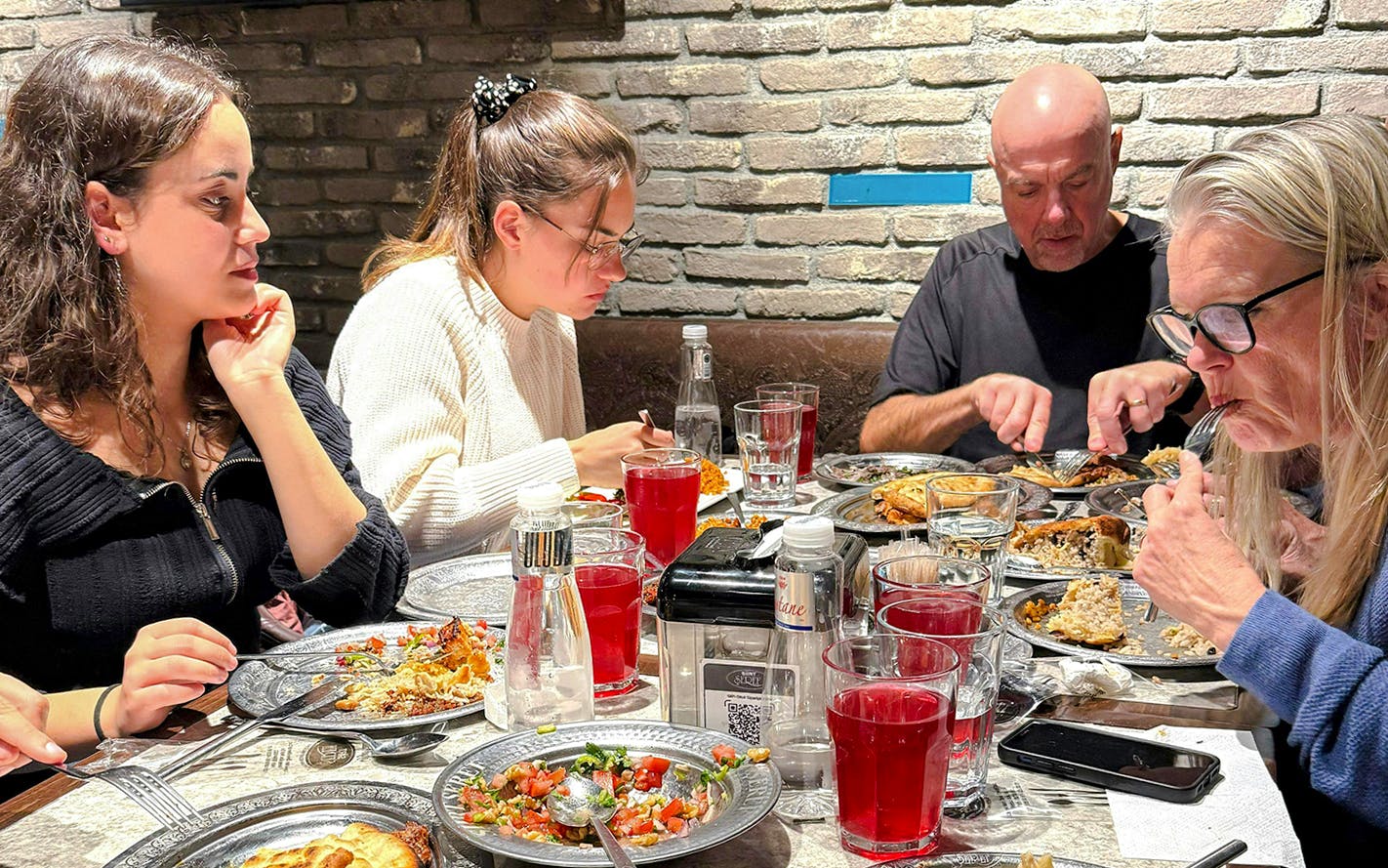 Group enjoying traditional Turkish dinner with assorted dishes in Istanbul restaurant.