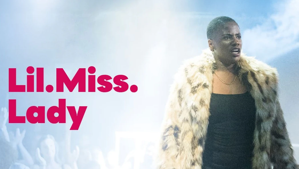 Performer in fur coat on stage with "Lil.Miss.Lady" text.