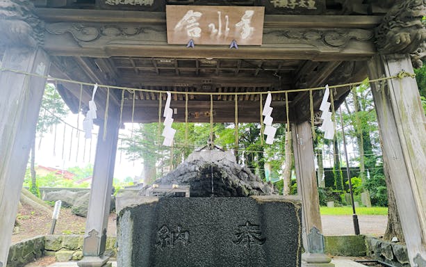 Shrine structure at Oshino Hakkai, Japan, with traditional wooden architecture and sacred ropes.