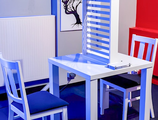 Two chairs and a table with an optical illusion exhibit at DeJa Vu Museum.