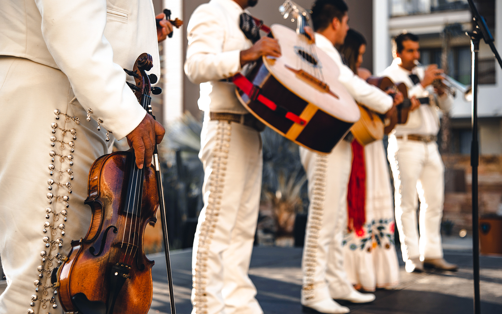 Mexican mariachi band performing in traditional attire with guitars and trumpets in Mexico City.