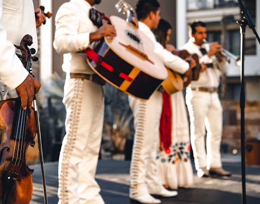 Mexican mariachi band performing in traditional attire with guitars and trumpets in Mexico City.