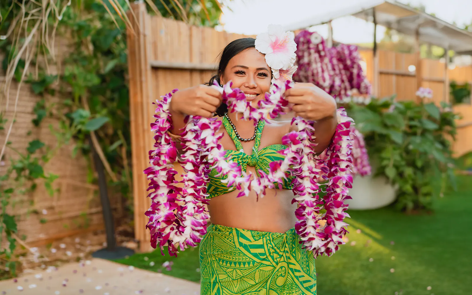 Performer holding flower leis at Mauka Warriors Luau.
