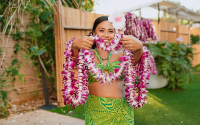 Performer holding flower leis at Mauka Warriors Luau.