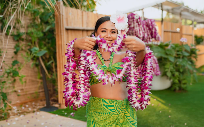 Performer holding flower leis at Mauka Warriors Luau.