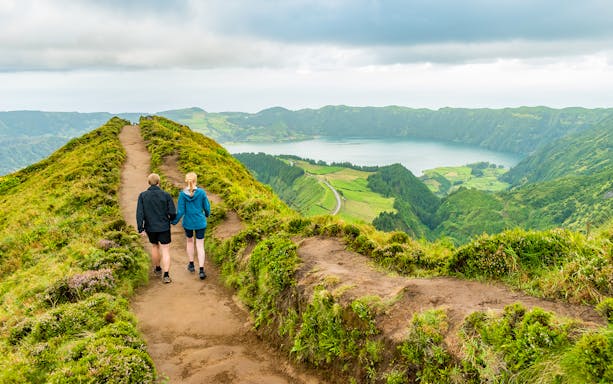 Hikers on trail overlooking Sete Cidades crater lake, Azores.