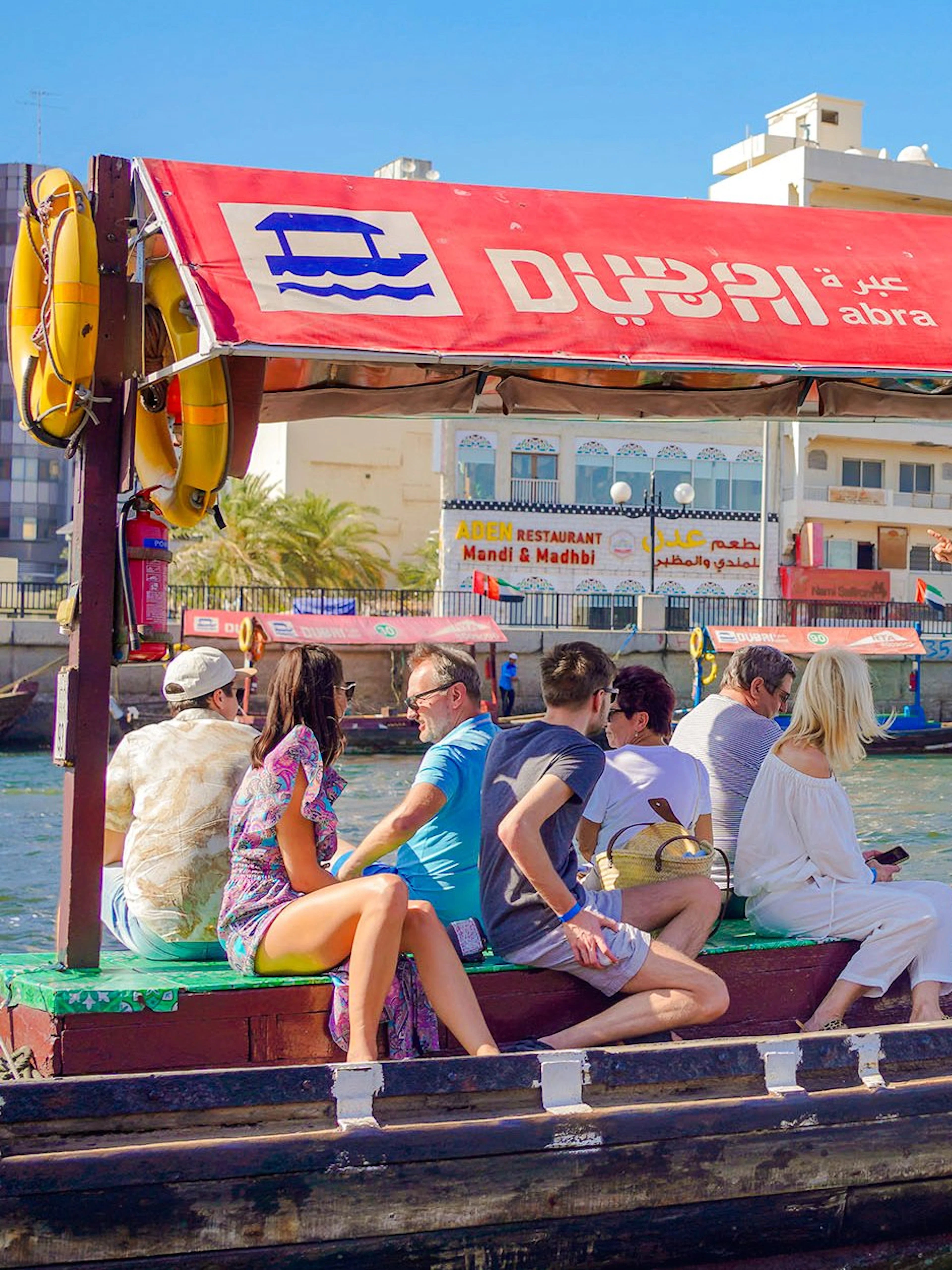Tourists on a traditional Abra boat ride in Dubai Creek, UAE.