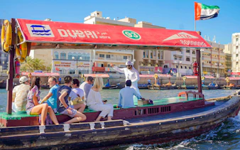Tourists on a traditional Abra boat ride in Dubai Creek, UAE.