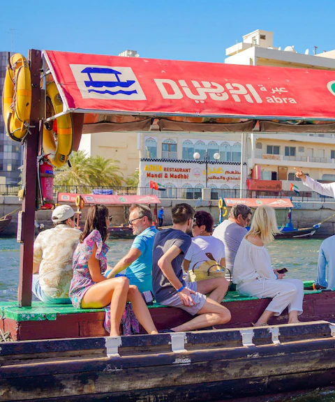 Tourists on a traditional Abra boat ride in Dubai Creek, UAE.