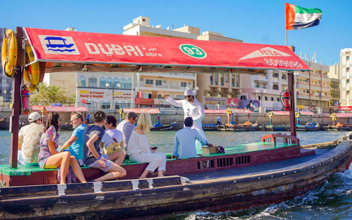 Tourists on a traditional Abra boat ride in Dubai Creek, UAE.