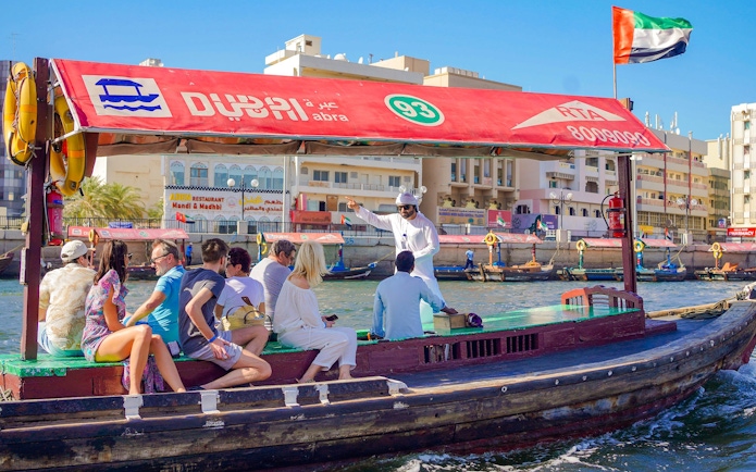 Tourists on a traditional Abra boat ride in Dubai Creek, UAE.