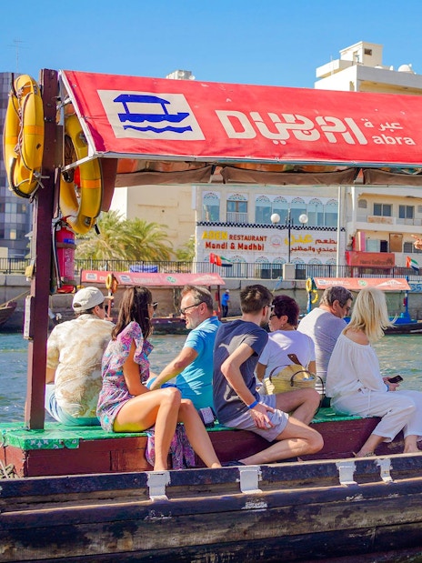Tourists on a traditional Abra boat ride in Dubai Creek, UAE.