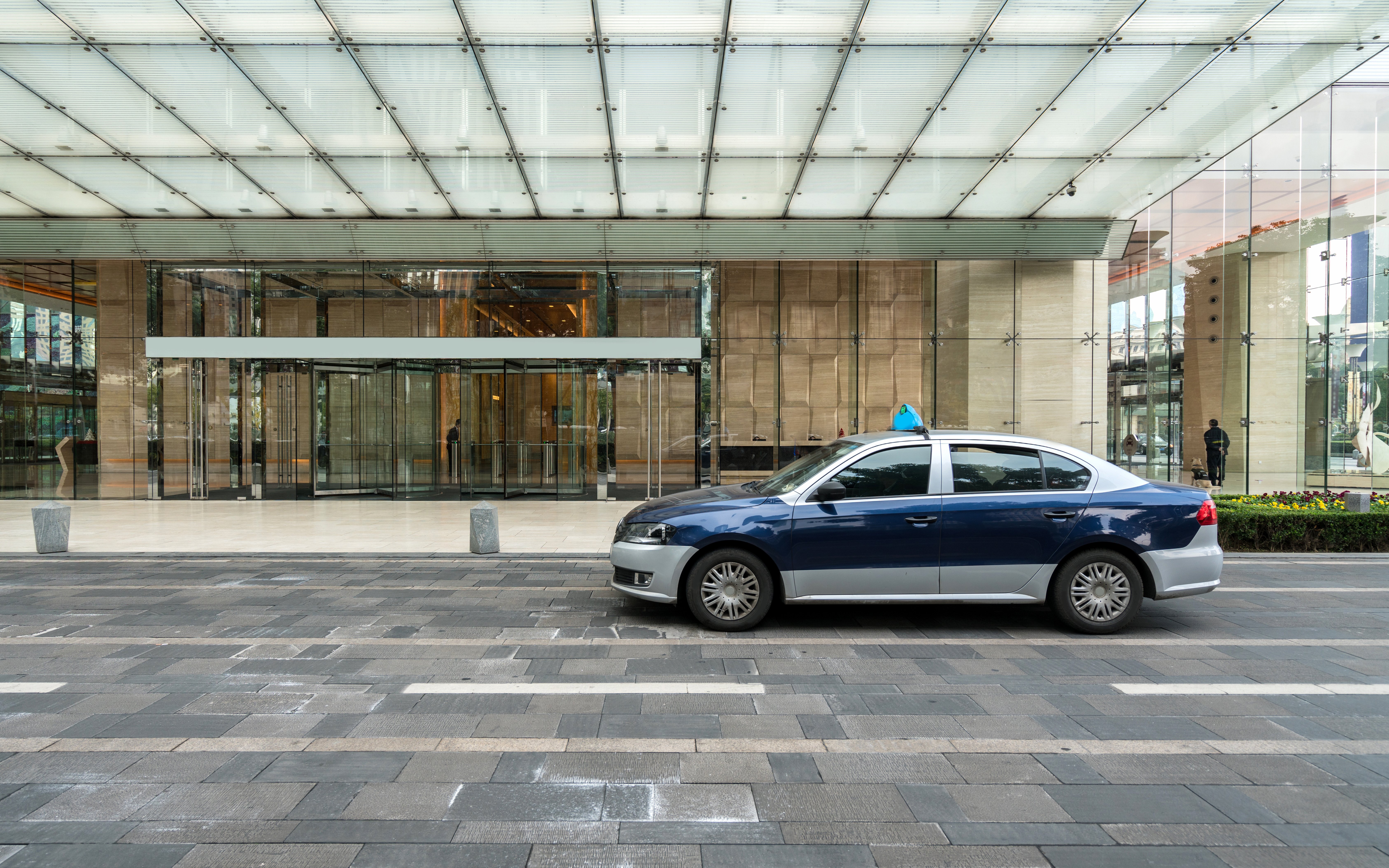 Taxi parked in front of a modern glass building 