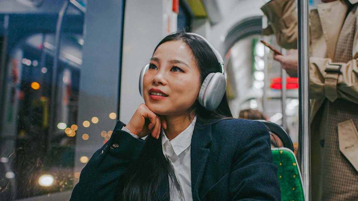 Woman listening to music on night bus.