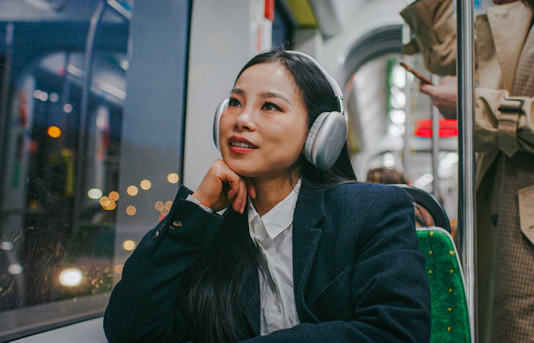 Woman listening to audio guide on night bus tour.