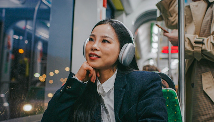Woman listening to audio guide on night bus tour.