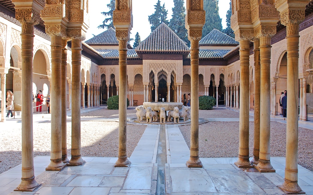 Court of the Lions, Alhambra, featuring central fountain with lion sculptures and intricate arches.