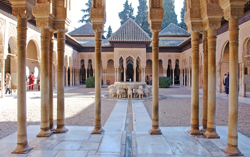 Court of the Lions, Alhambra, featuring central fountain with lion sculptures and intricate arches.