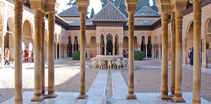 Court of the Lions, Alhambra, featuring central fountain with lion sculptures and intricate arches.