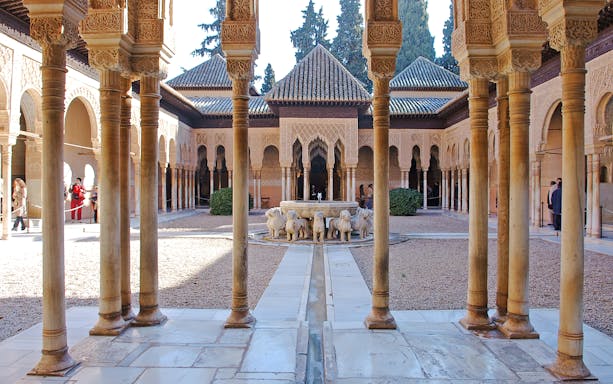 Court of the Lions, Alhambra, featuring central fountain with lion sculptures and intricate arches.