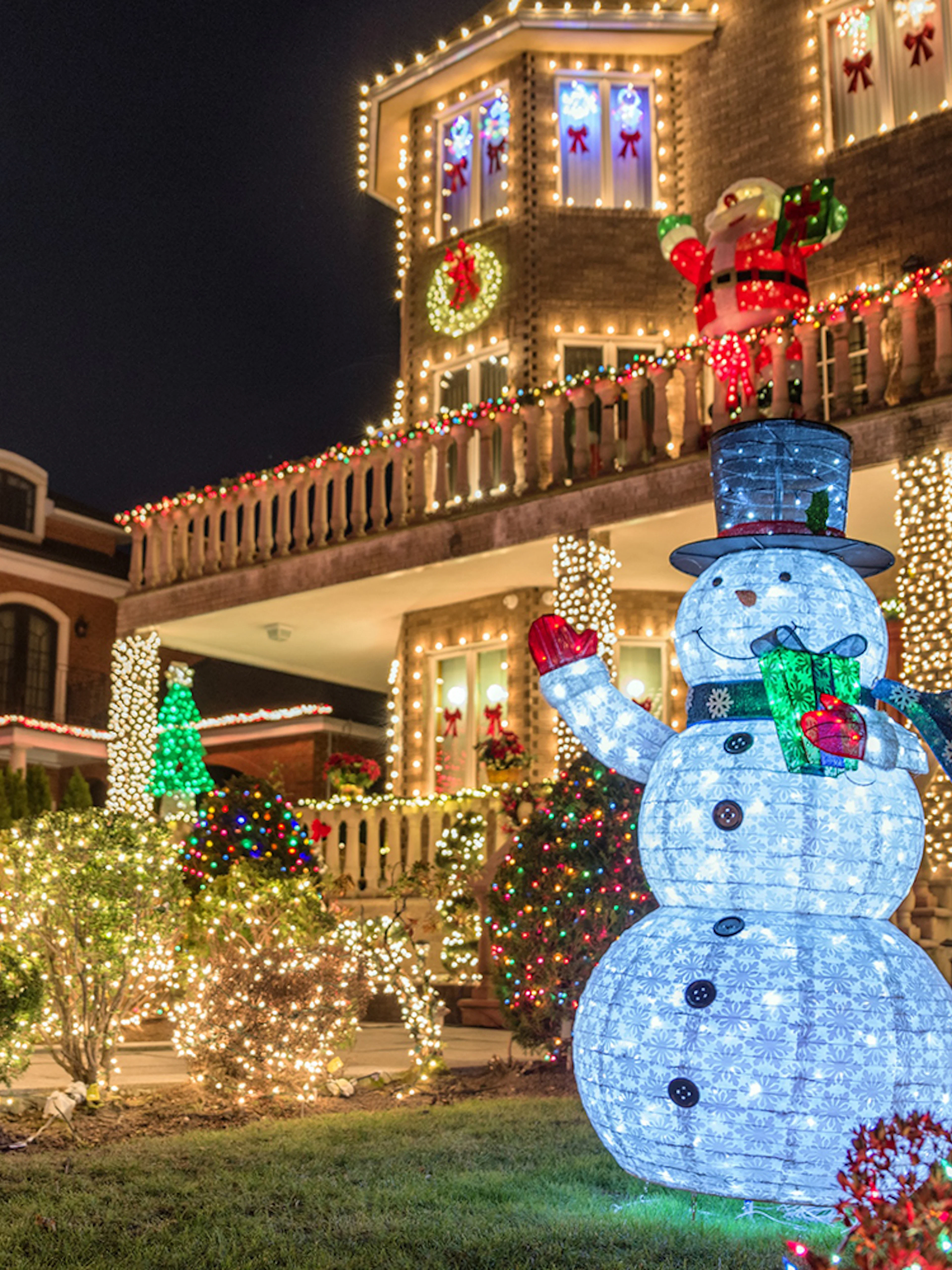 Christmas lights display with snowman and decorated house on New York bus tour.