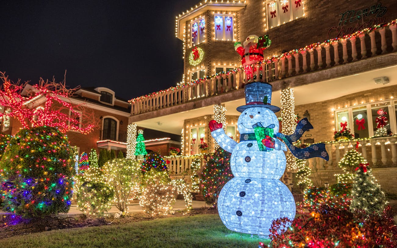 Christmas lights display with snowman and decorated house on New York bus tour.