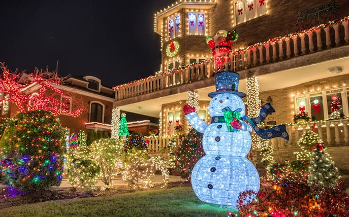 Christmas lights display with snowman and decorated house on New York bus tour.