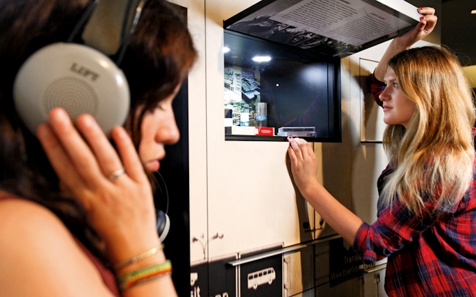 Visitors interacting with exhibits at DDR Museum Berlin.