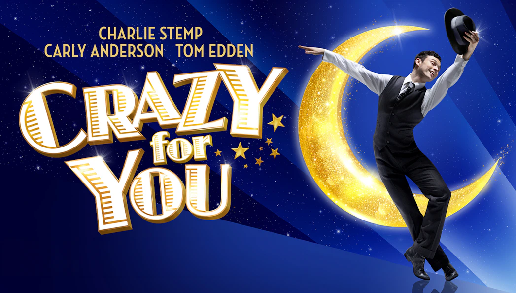 Performer dancing with hat in front of a crescent moon for "Crazy For You" show.
