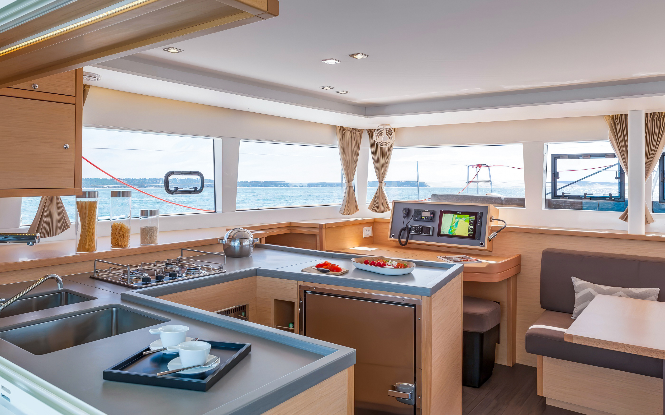 Catamaran interior with kitchen and dining area, Heraklion cruise experience.