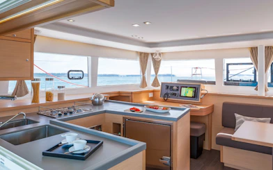 Catamaran interior with kitchen and dining area, Heraklion cruise experience.