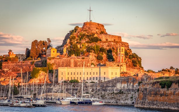 Old Venetian Fortress with clock tower and yachts in Corfu town, Corfu Island, Greece.