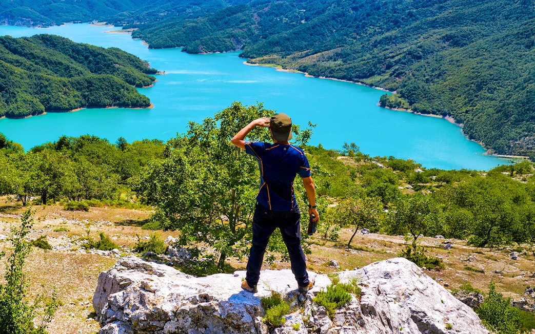 Male hiker on Gamti Mountain overlooking Bovilla Lake, Albania.