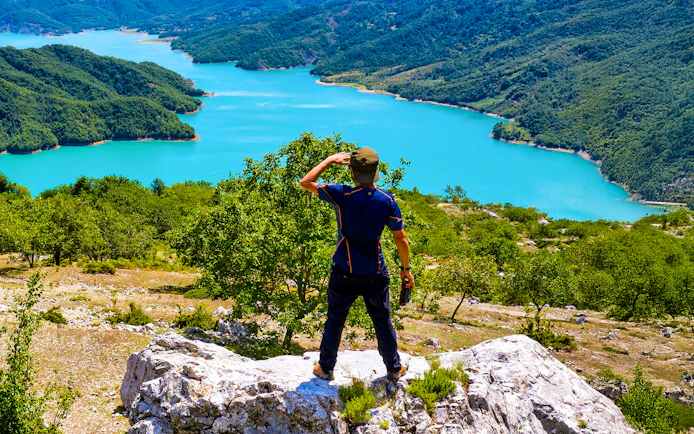 Male hiker on Gamti Mountain overlooking Bovilla Lake, Albania.