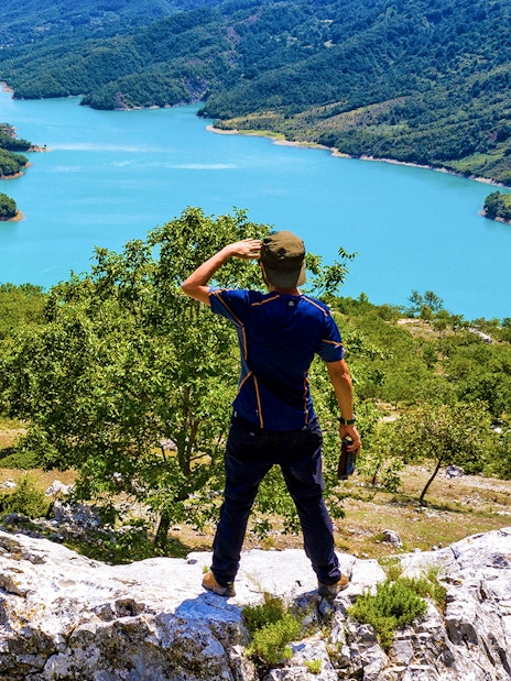 Male hiker on Gamti Mountain overlooking Bovilla Lake, Albania.