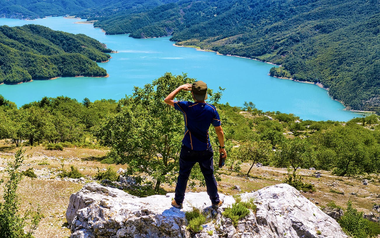 Male hiker on Gamti Mountain overlooking Bovilla Lake, Albania.