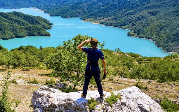Male hiker on Gamti Mountain overlooking Bovilla Lake, Albania.