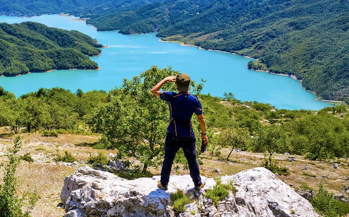 Male hiker on Gamti Mountain overlooking Bovilla Lake, Albania.