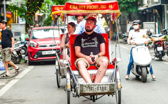 Cyclo ride through Hanoi street near Temple of Literature and Ho Chi Minh Complex.